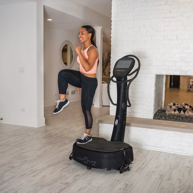 A woman exercising on a Power Plate vibration machine